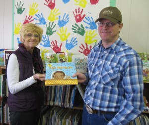 Paton librarian Joleen Allen accepts book from Barry Anderson