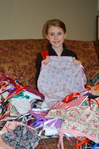 Hannah with a pile of completed dresses