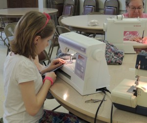 Hannah at work, with Grandma sewing next to her