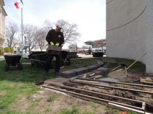 Dave Briggs hauls a 75-pound landscaping brick at the base of the Bell Tower