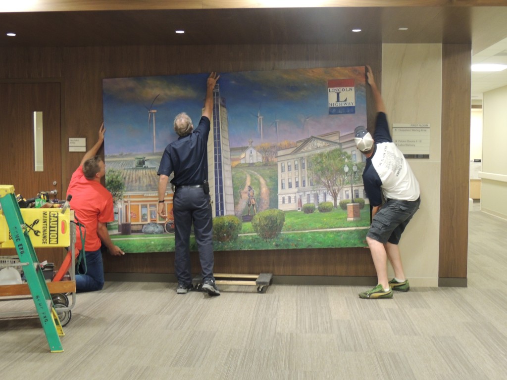 Artist Zack Jones (left), medical center physical plant director Steve Jackson, and Jones' friend Tyler Bartley (right) installed the 6 X 9-foot mural Sept. 21.