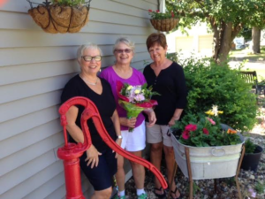 Jefferson Garden Club members Jerilyn Denman (left) and Sue Lucht flank July Yard of the Month winner Nancy Morris who takes a colorful and whimsical approach to gardening.