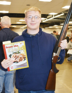 Brandon Childs won a nice gun after purchasing one of 10 cookbooks on the auction. He also won the pick of the auction, selecting a 9 mm pistol. | Scranton Journal photo